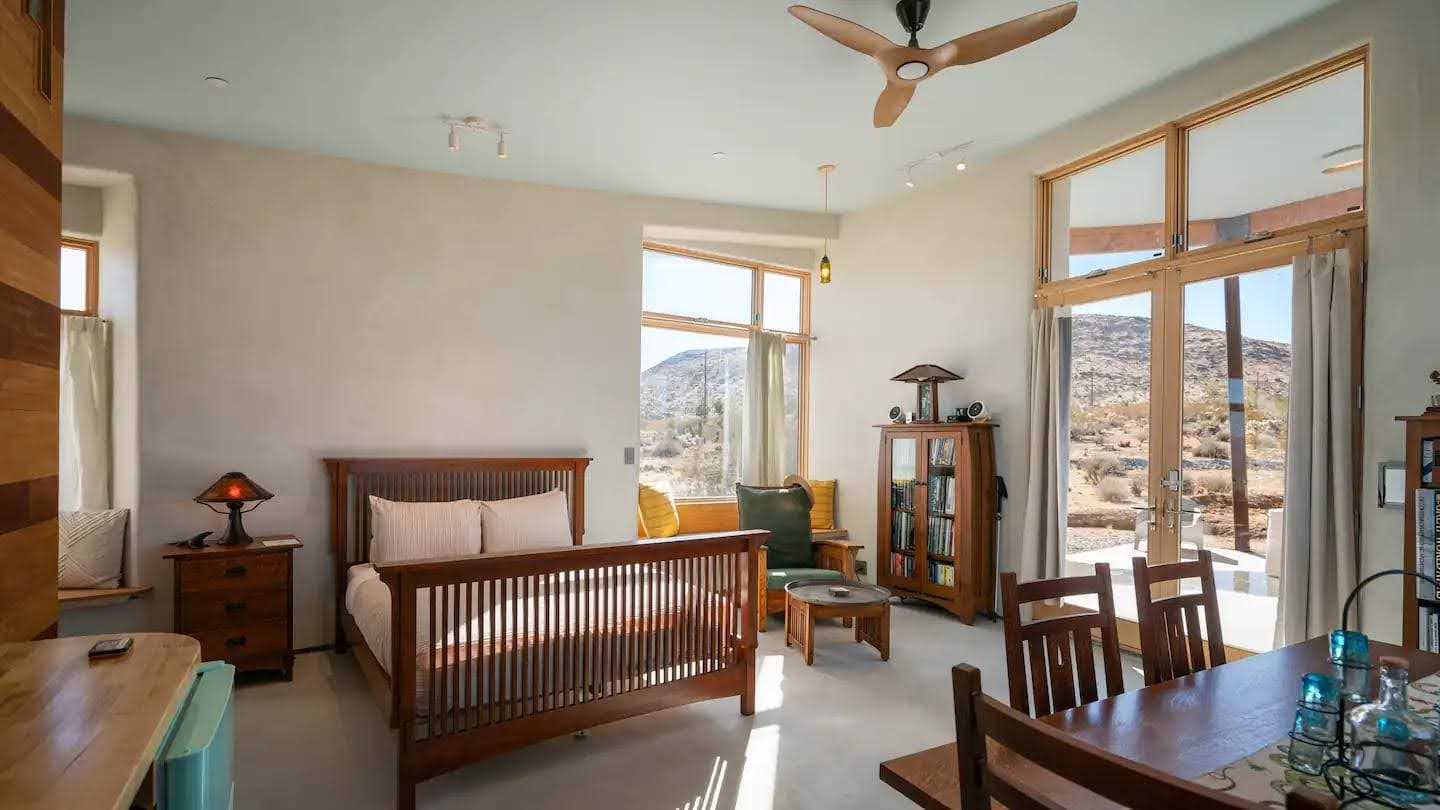 A daylight interior of a Mesa Sky Disk guest suite, desert visible through the windows.